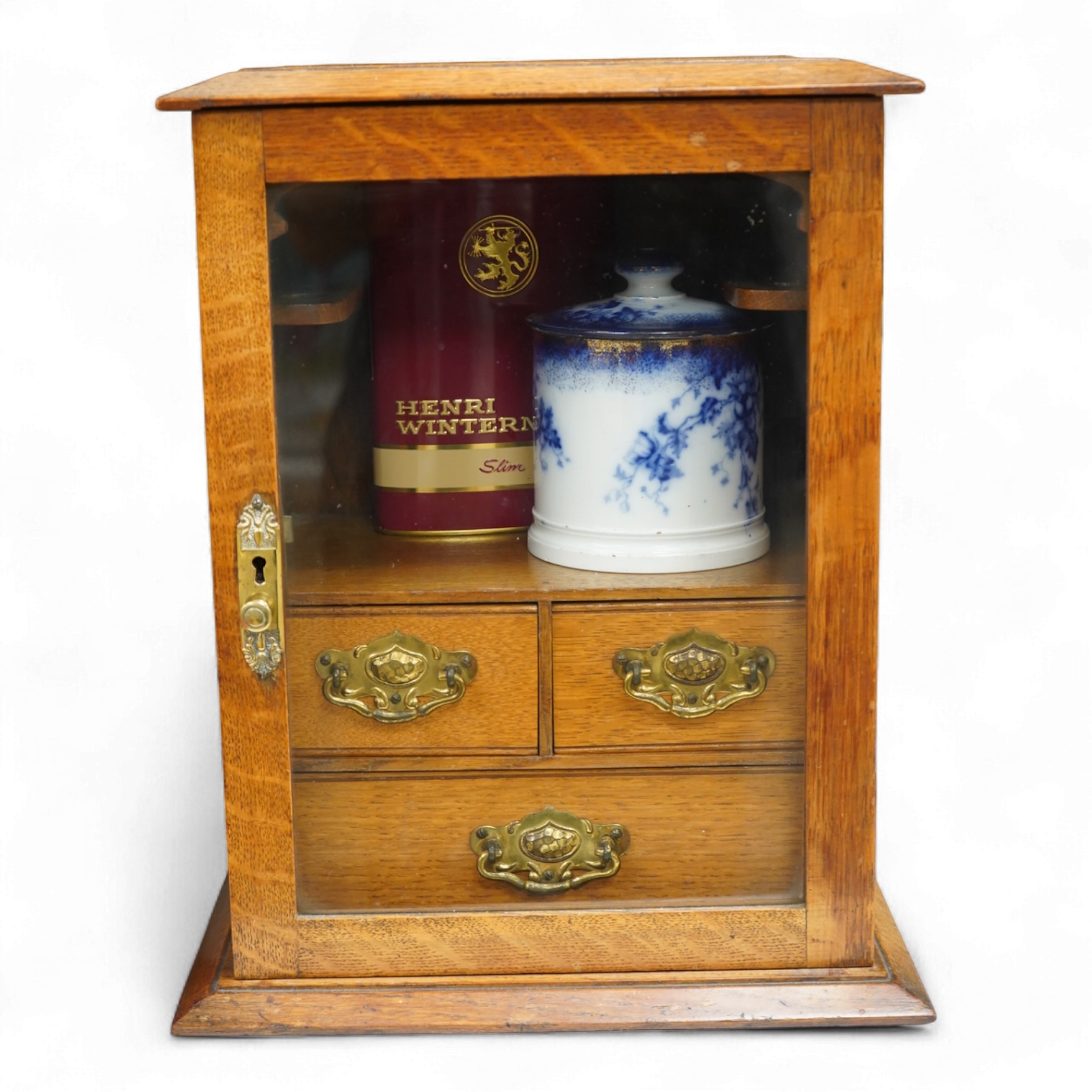 An Edwardian oak smoker's cabinet, with Doric blue and white tobacco jar and cover, 38cm high x 29.5cm wide.